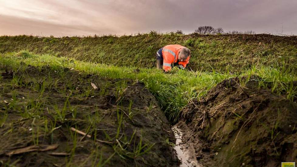 Aan de rand van een landbouwperceel onderwerpt Boom een door de boer zelf gemaakte afwateringssleuf aan een nadere inspectie.