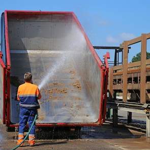 De chauffeur spuit direct de mestcontainers schoon. Rechts is de aanvoerband voor stro zichtbaar. In totaal werken bij Walko 240 medewerkers.