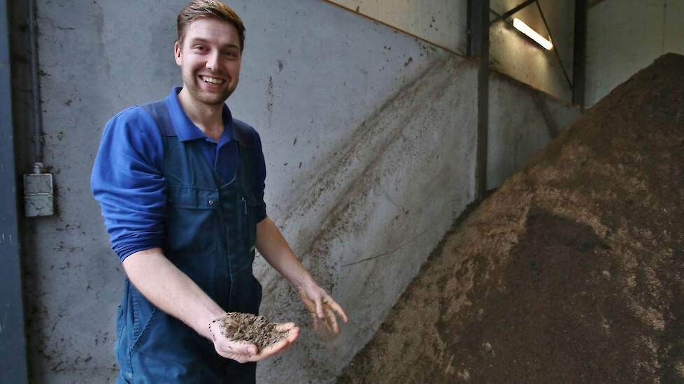 Bedrijfsleider Sjef de Bruijn (27) met in zijn hand wat dikke fractie mest.