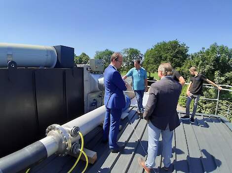 Klaas de Boer (tweede van links) geeft uitleg over zijn uitvinding, de ammoniakfilter.