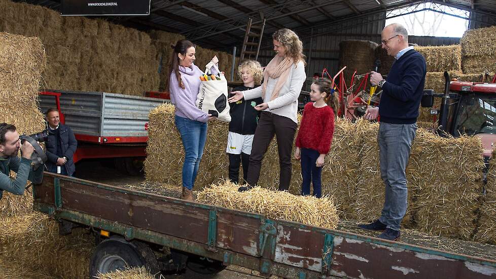 Boerin Wendy van den Kieboom (L) overhandigt een tas met producten van BOER&NLekker aan de eerste klant mevrouw Annemiek Messer (40) met haar zoon Guus (7) en dochter Saar (9). Agrifirm-directeur Dick Hordijk (R) kijkt toe.