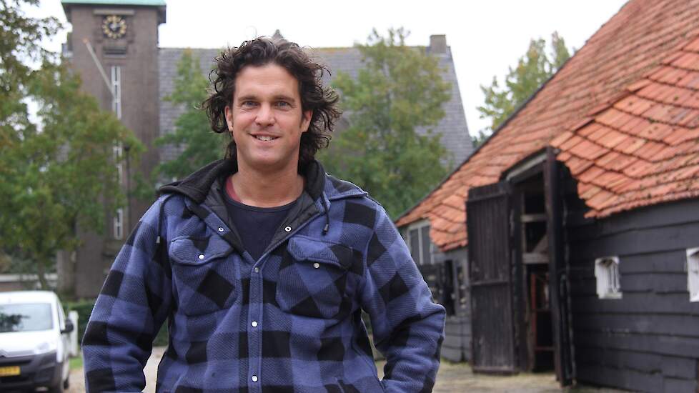 Jos van Damme op zijn erf, op de achtergrond de kerk.