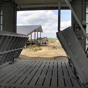 De dieren uit de oude stal lopen via buiten. Twee delen van de voergang worden automatisch opgetrokken (op de foto nog niet geheel omhoog)zodat zich een loopbrug vormt en de voergang schoon blijft.